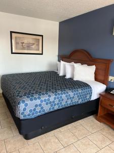 罗斯威尔Budget Inn的一间卧室配有一张蓝色墙壁的床