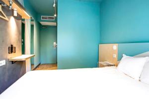 蒙彼利埃蒙彼利埃千禧中心宜必思酒店的一间卧室设有一张大床和蓝色的墙壁