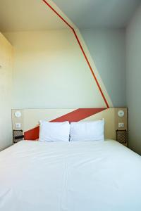 蒙彼利埃蒙彼利埃千禧中心宜必思酒店的一间卧室配有一张白色大床和红色床头板