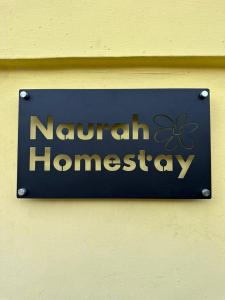 古来Naurah Homestay Kulai Mslim Only的墙上挂有笑柄挂衣的标志