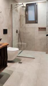 帕尔加MiLiON RESIDENCES的一间带玻璃淋浴和卫生间的浴室