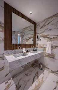 圣地亚哥-德尔埃斯特罗HT Hotel Deluxe Resort & SPA的大理石浴室配有水槽和镜子