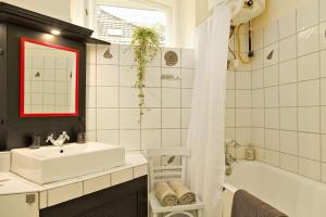 沙罗什保陶克Kurucz Apartman的浴室配有白色水槽、浴缸和淋浴