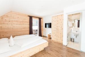 毛特恩多夫Rest Apartments & Suiten的卧室配有一张白色的大床和木墙
