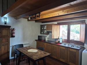 摩亚CASA COMPLETA CON PISCINA PRIVADA El ROBLE的厨房配有桌子、水槽和窗户