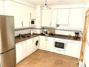 比利亚维西奥萨Apto La Manzanina con Parking的白色的厨房配有白色橱柜和洗碗机。
