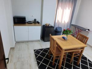 开罗Comfort suite的小厨房配有木桌、椅子和桌子