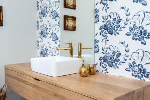 库特诺CukroVia的浴室设有白色水槽和蓝色及白色的壁纸