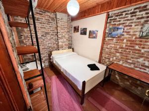 克鲁亚Rooms Nesti INSIDE OF CASTLE的小房间,设有床和砖墙