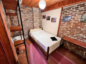 克鲁亚Rooms Nesti INSIDE OF CASTLE的小房间,砖墙里设有一张床铺