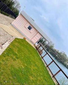 奇切斯特Lake View Lodge Pod的水体上方的粉红色房子