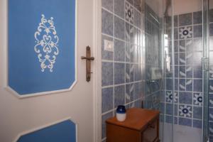 阿夸维瓦皮切纳La Casa del Gelsomino的浴室设有蓝色瓷砖墙壁和淋浴。