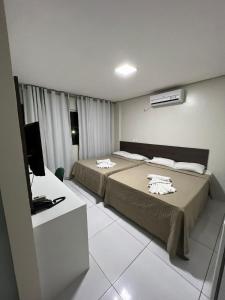 特雷西纳RILL HOTEL BY UCHÔA的酒店客房设有两张床和电视。