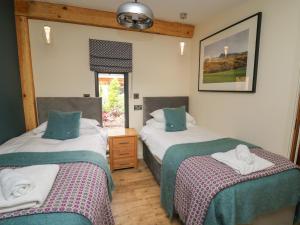 威尔斯浦Celyn的一间卧室设有两张床和窗户。