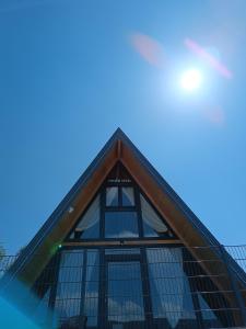 亚伊采Stone Chalets - TERRA的一座带玻璃窗户的尖顶建筑