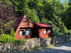 米迪格兹Domek nad potokiem的石墙旁的一座红色小房子