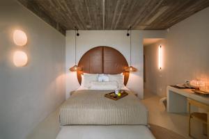艾福雷诺德Euforia Retreat and Spa的一间卧室配有一张大床和木制床头板