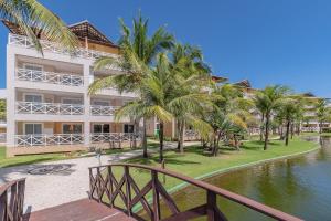 阿奎拉兹Portamaris Resort #101 - Apartamento de Luxo em Porto das Dunas Por Carpediem的棕榈树环绕在水体上的建筑