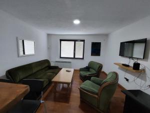 萨拉热窝Hostel Bobito的客厅配有绿色家具和平面电视