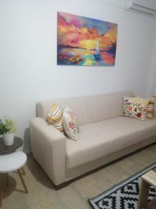 阿尔戈斯托利翁Argostoli Elia's Maisonette的客厅的沙发,墙上有绘画作品