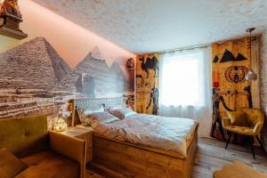 特尔乔夫PARADiSE Wellness Residence的一间卧室,配有一张带金字塔壁画的床