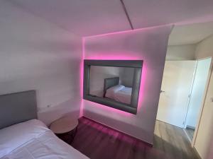 奥伦塞LA Lujuria的客房设有壁炉和带粉红色灯的床。