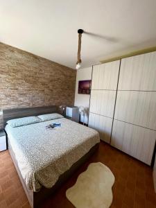 克雷米亚La bettola di cremia的一间卧室设有一张床和砖墙