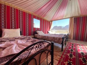 DisahDesert's Soul Wadi Rum的一间设有两张床铺的卧室,位于带红色墙壁的房间