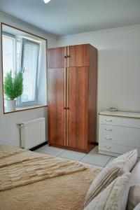 卡缅涅茨-波多利斯基Vacation home Lubov的卧室配有木制橱柜,位于床边