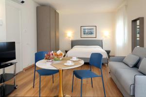 巴多利诺Ancora Suites的酒店客房带一张床、一张桌子和椅子