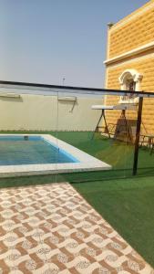 延布شاليه سحاب的一座游泳池,旁边是一座建筑,设有玻璃围栏