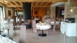 Ménilles多梅恩德拉海德斯格兰丝酒店的餐厅设有白色的桌椅和壁炉