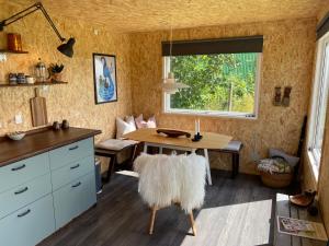 SkibbyCozy Tiny House on a farm的一间带桌子和窗户的用餐室