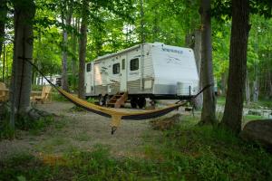 Miller LakeGrotto Getaway的森林中挂在拖车上的吊床