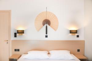 蒂加基Philippos & Alexandros Apartments的床上墙上的时钟,有两盏灯