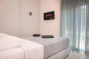 蒂加基Philippos & Alexandros Apartments的一间卧室配有一张床,上面有两条毛巾