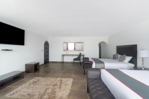 普埃布拉Collection O Hotel Nueva Escocia, Puebla的酒店客房设有两张床和一台平面电视。