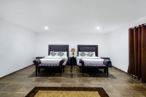 普埃布拉Collection O Hotel Nueva Escocia, Puebla的一间卧室配有两张床和两把椅子