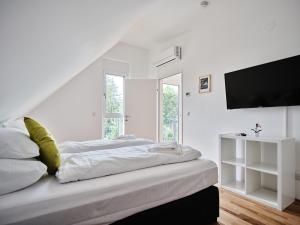 维也纳MySchönbrunn Apartments的白色卧室配有床和平面电视