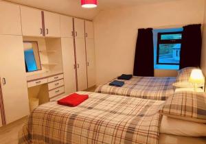 CloghanReelin bar holiday Accommodation的宿舍间内的两张床,上面有红色的毛巾