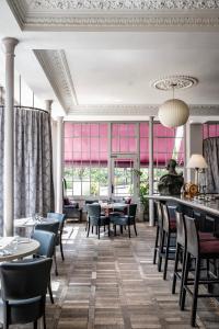 伦敦约克加奥尔巴尼酒店的用餐室配有桌椅和粉红色的窗户