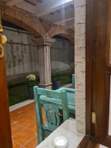 危地马拉安地瓜Casa Miranda的一张蓝色的椅子,坐在带拱门的庭院里