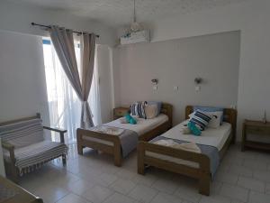 卡尔扎迈纳米纳公寓酒店的一间卧室设有两张床、一把椅子和一个窗户。