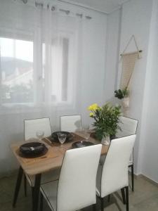 阿尔戈斯托利翁Argostoli Elia's Maisonette的餐桌、白色椅子和木桌