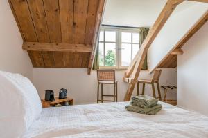 雷讷瑟Fika的卧室配有白色的床铺和木制天花板