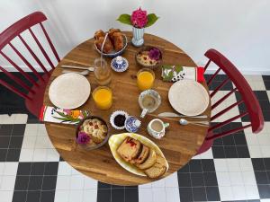 Venez Vernou的一张带早餐食品和橙汁的木桌