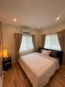 Ban Khlong PrawetAnna Home@Lat Krabang的卧室配有白色的床和2扇窗户。