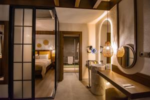 特拉布宗Hayal Vadisi Suite Hotel的一间带一张床的卧室和一间带镜子的浴室