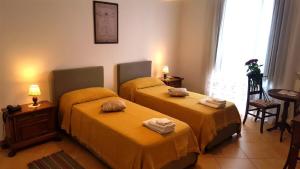 皮佐Palazzo Zimatore Residenza D'Epoca的配有黄色床单的客房内的两张床