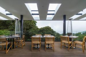 蒙泰韦尔德哥斯达黎加Koora Monteverde-a Cloud Forest Hotel by Sandglass的一间带桌椅的用餐室和大窗户